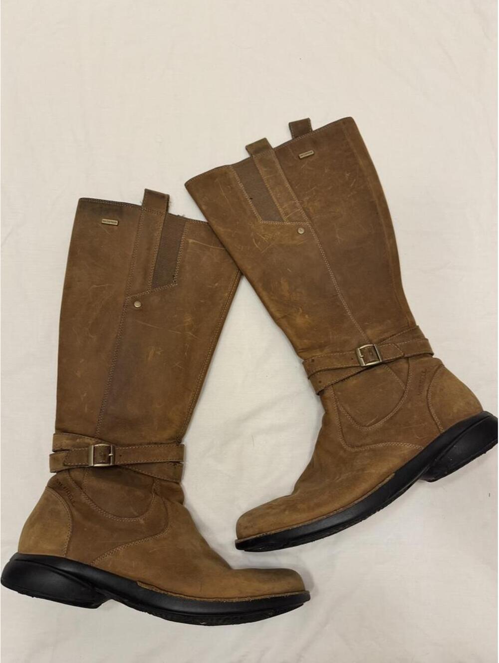 Merrell waterproof brown knee-high boots with a rugged, outdoor vibe